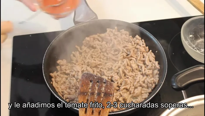 Añadir dos o tres cucharadas de tomate frito a la carne y mezclar bien. Reservar.