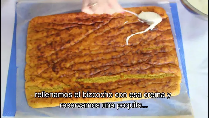Desenrollar el bizcocho y rellenarlo con la crema de queso (reservar un poco para la decoración).