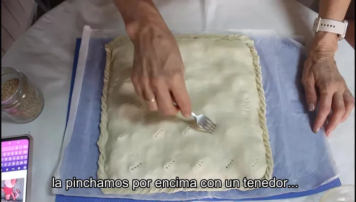 Pinchar la empanada con un tenedor y pintar con huevo batido. (86.079)