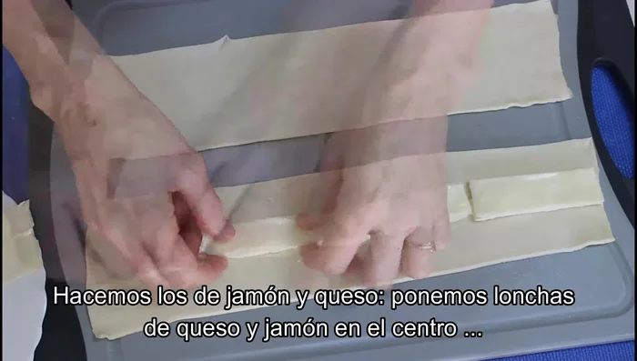Para los saladitos de jamón y queso: Colocar lonchas de queso y jamón partidas por la mitad en el centro de una tira, pintar los bordes con huevo, enrollar, dar la vuelta, pintar con huevo y espolvorear. Cortar en trocitos.