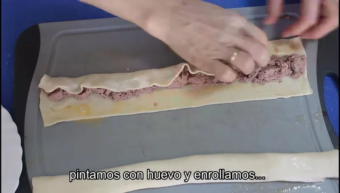 Para los saladitos de paté: Extender el paté en el centro de la última tira, pintar los bordes con huevo, enrollar, dar la vuelta, pintar con huevo y espolvorear. Cortar en trocitos.