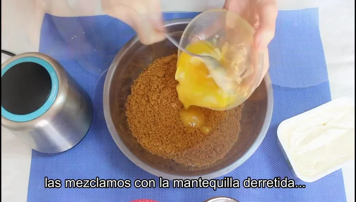 Añadir la mantequilla derretida a las galletas trituradas y mezclar bien.