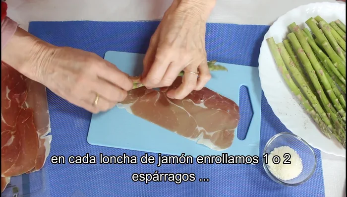 Enrollamos uno o dos espárragos en cada loncha de jamón (dependiendo del grosor del jamón).