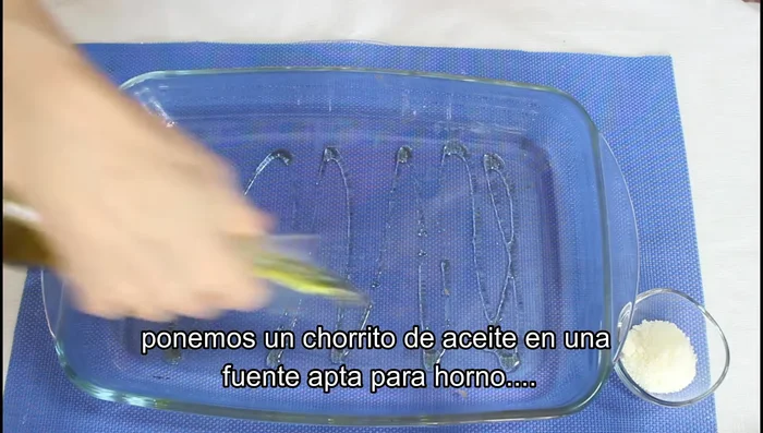 Colocamos los espárragos enrollados en jamón en una fuente de horno previamente untada con un poco de aceite.
