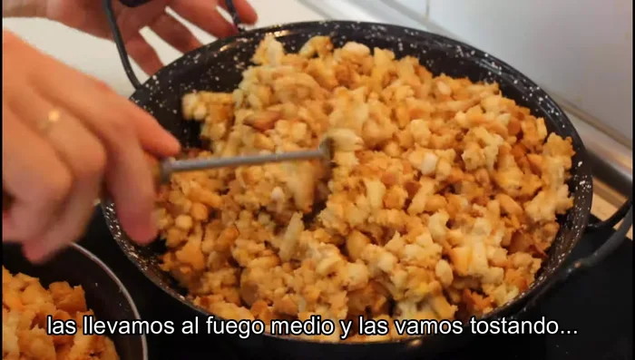 Llevar a fuego medio y tostar las migas poco a poco, removiendo ocasionalmente, hasta que pierdan el exceso de humedad y queden sueltas.