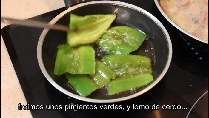 Freír los pimientos verdes troceados, las rodajas de lomo, la panceta y el chorizo. Reservar.
