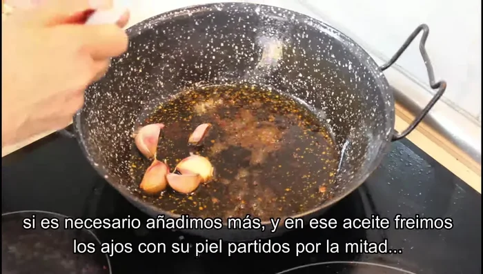 En una sartén grande, con el aceite donde se frieron las carnes, freír los ajos con piel, partidos por la mitad, hasta que estén dorados.