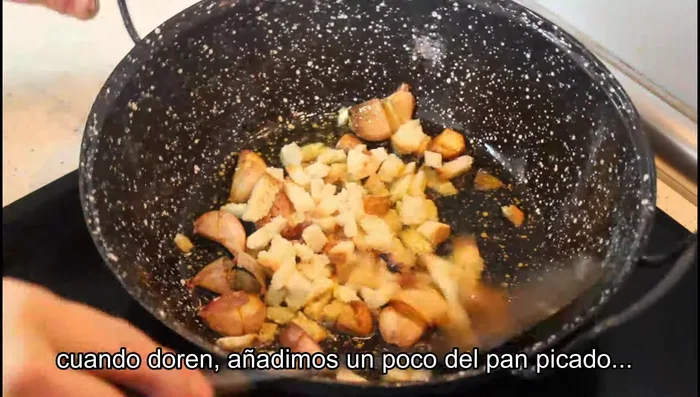 Añadir parte del pan picado, freír un poco, añadir sal al gusto y una cucharadita de pimentón dulce. Rehogar.