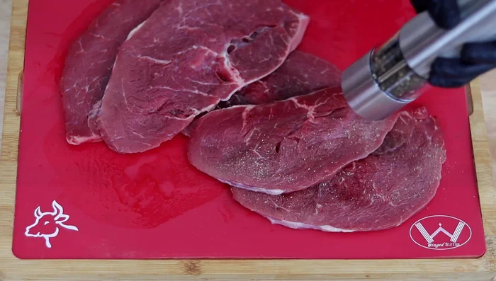 Conseguir un buen corte de carne (de cadera o babilla son excelentes). Condimentar con pimienta, sal, orégano y ajo. Si el corte no es bueno, añadir también naranja agria o limón y dejar reposar en el refrigerador por al menos 1 hora.