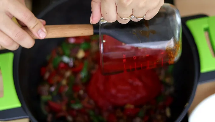 Agregar puré de tomate, vino blanco, caldo de pollo y salsa de soja. Integrar todo y acomodar el pollo. Cocinar a fuego medio-bajo por 15 minutos con la olla tapada.