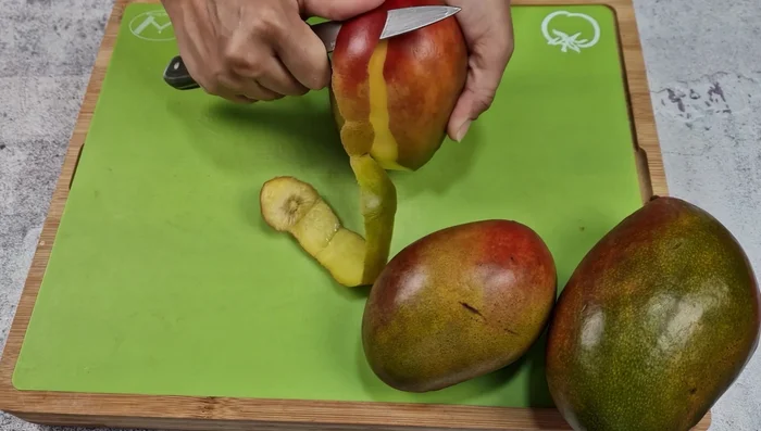 Pelar y cortar la pulpa de los mangos en trozos.