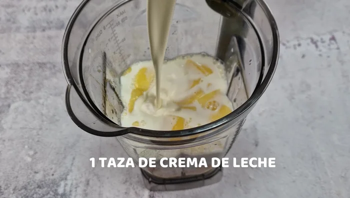 Licuar la pulpa de mango con el azúcar, la leche y la crema de leche hasta que no queden trozos.