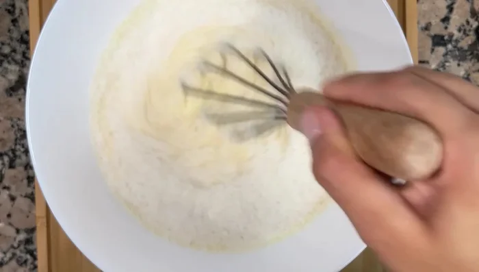 Agregar el coco rallado a la mezcla del flan y mezclar bien.