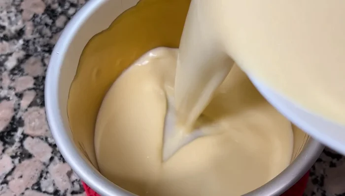 Cocer al baño maría: Colocar el molde dentro de una olla con agua caliente, cubriendo hasta casi la mitad del molde. Cocinar a fuego medio (para flan con huequitos) o fuego bajo (para flan sin huequitos) durante 50-55 minutos.