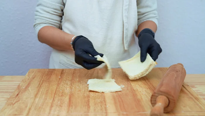 Superponer ligeramente dos rebanadas de pan. Colocar encima lonchas de queso mozzarella.