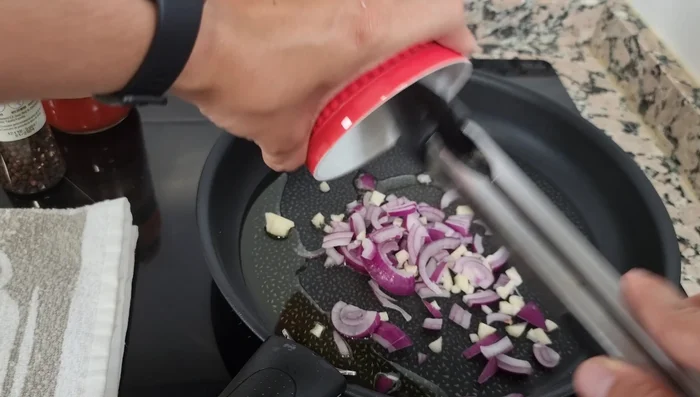 Sofreír el ajo y la cebolla (2 minutos). Agregar el pollo desmenuzado y un poco de puré de tomate. Cocinar hasta que espese un poco.