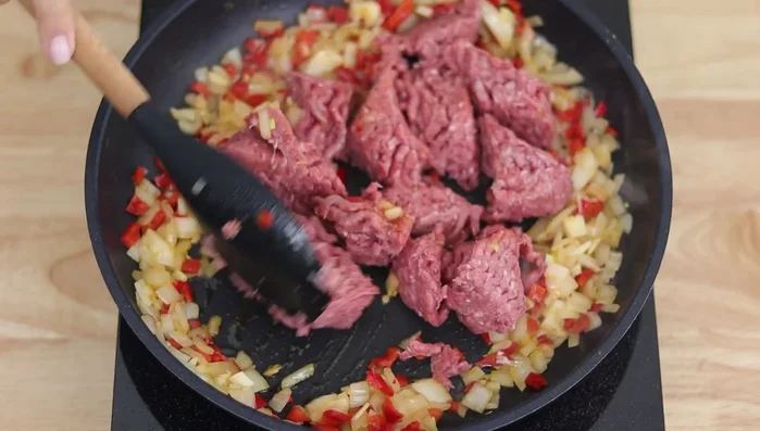 Añadir el picadillo de carne y cocinar a fuego medio-alto hasta que esté listo. Sazonar con sal, pimienta, orégano, pimentón dulce o paprika y puré de tomate (123.6)