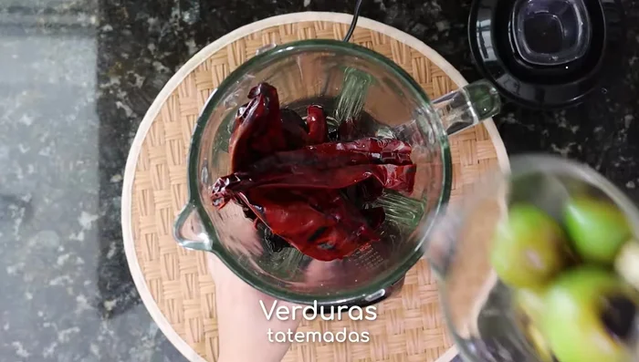 Licuar los chiles hidratados con las verduras tatemadas, sal, comino y orégano seco. Agregar 2 tazas de agua de los chiles y licuar hasta obtener una mezcla homogénea.