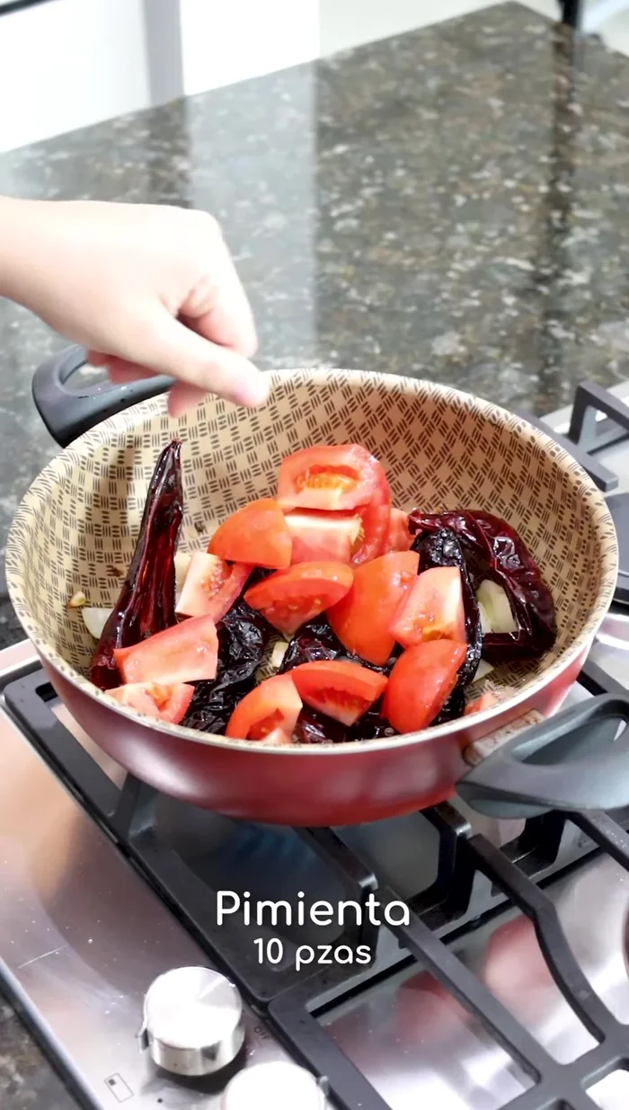 Agregar tomates picados, pimientas, clavos, canela, laurel y orégano. Cocer por un tiempo.