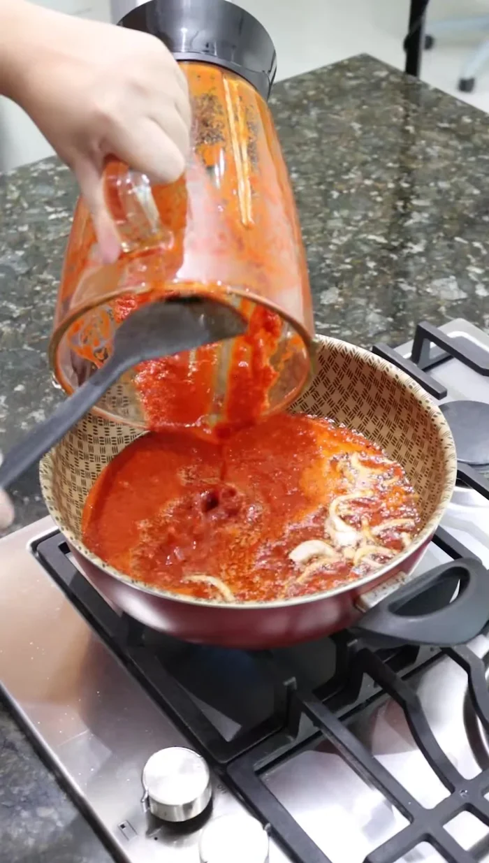 Agregar el adobo de chiles a la cebolla sofrita y guisar durante 10 minutos.