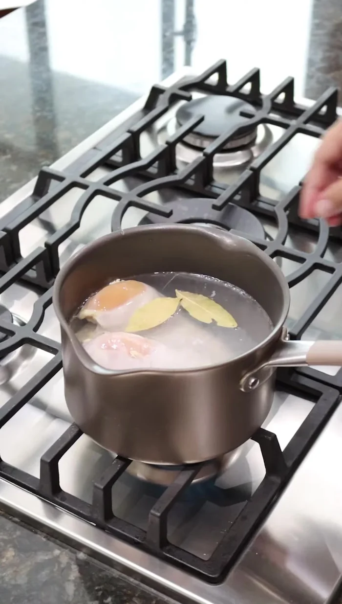 Cocer una pechuga de pollo en agua con 2 hojas de laurel, 1 diente de ajo, 1 rodaja de cebolla y sal, durante 25 minutos. Reservar.