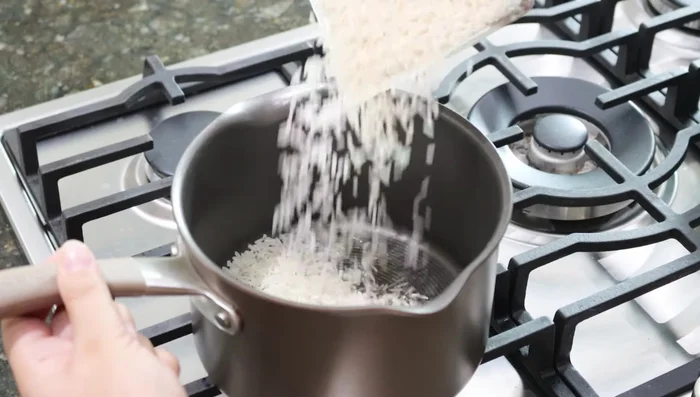 En otra sartén, agregar 1 taza de arroz y un chorrito de aceite (o mantequilla). Mover constantemente hasta dorar.