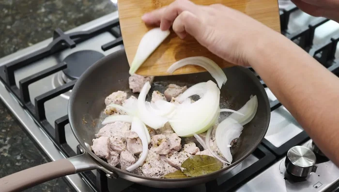 Agregar un chorrito de aceite, 1/2 cebolla cortada en julianas y mezclar hasta dorar.