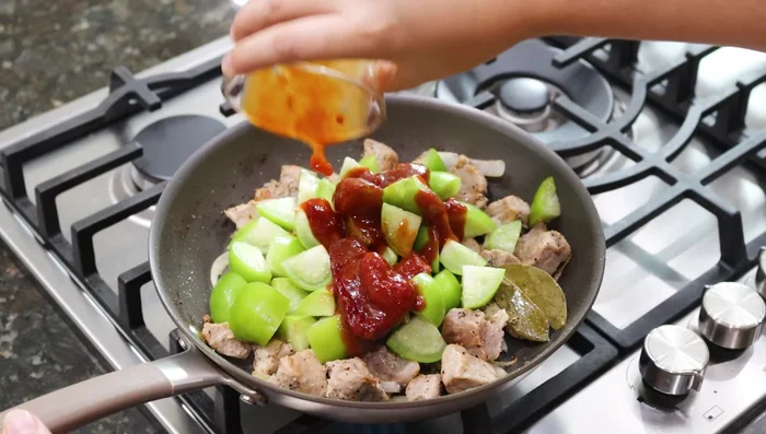 Agregar 6 tomatillos cortados en cubitos, 1/2 taza de chile chipotle y 1 taza de consomé de pollo. Mezclar bien.