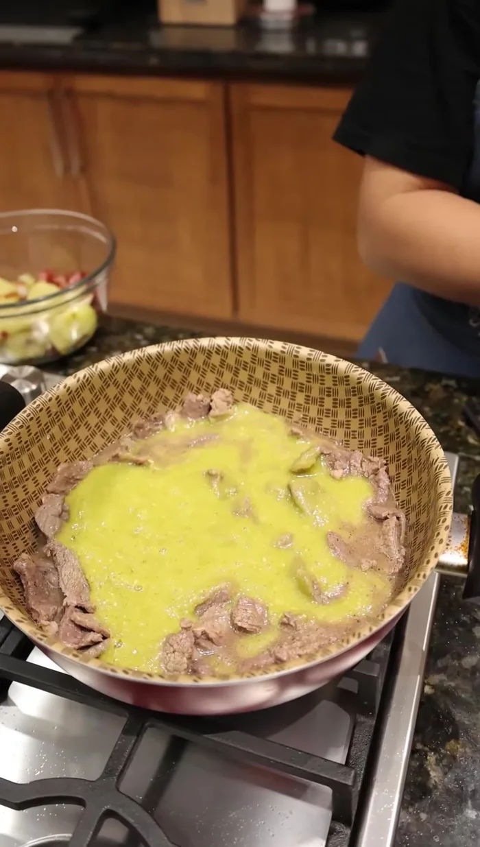 Agregar la salsa verde licuada, el tocino, los chiles güeros y las cebollitas doradas.