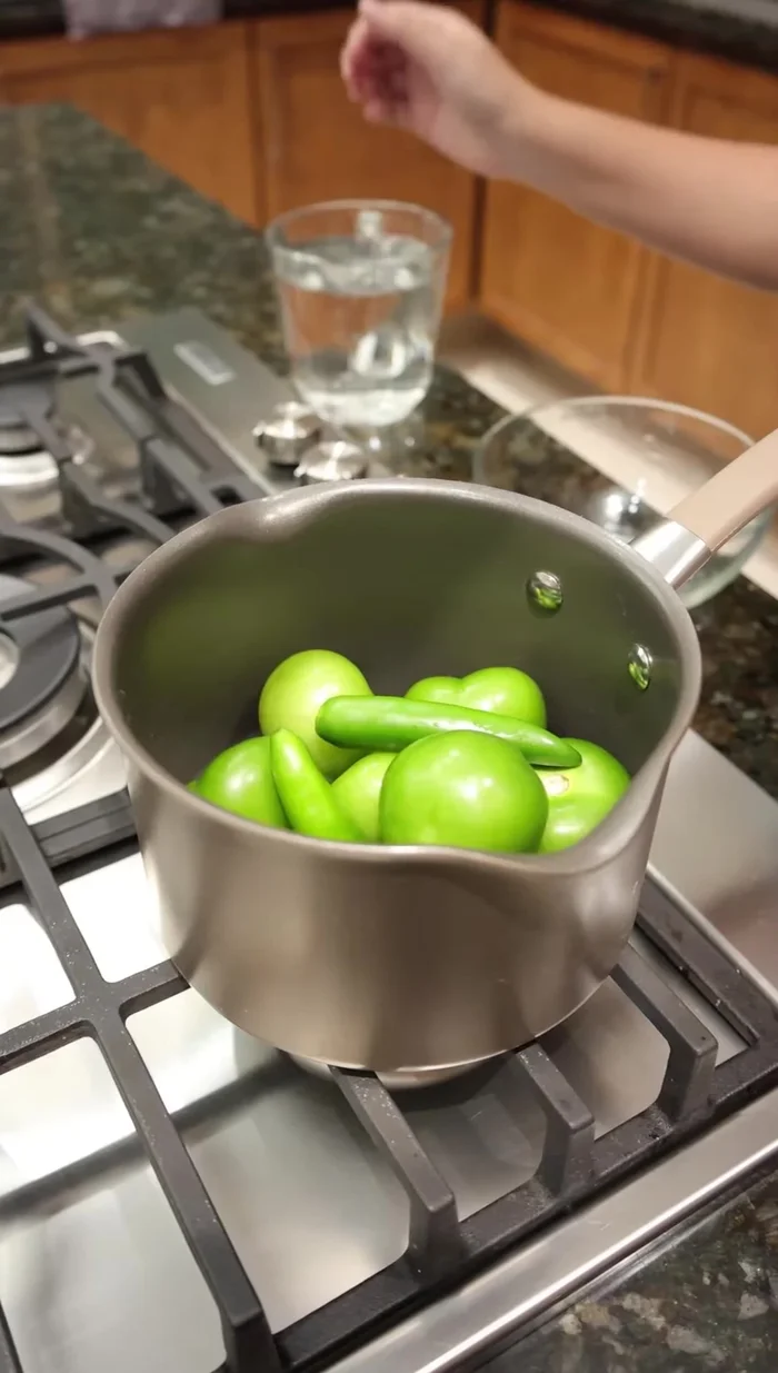 En una olla, poner ocho tomatillos, dos chiles verdes (o al gusto) y suficiente agua para cubrir. Tapar y cocinar por 15 minutos.