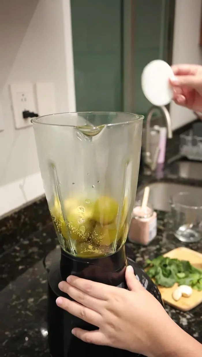 Vaciar las verduras cocidas en la licuadora. Agregar consomé de pollo, una rodaja de cebolla, cilantro fresco, dos dientes de ajo sin cáscara y una cucharadita de sal. Licuar.