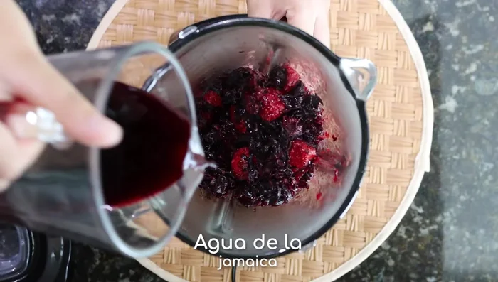Licúa la Jamaica y las fresas con media taza del agua reservada (ajusta la cantidad de agua según la consistencia deseada).