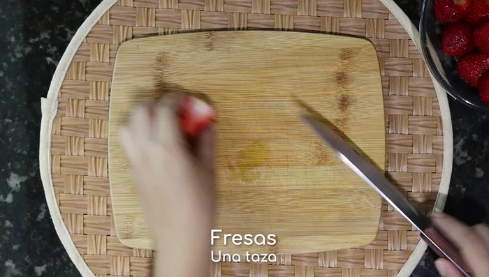 Mientras tanto, corta por la mitad aproximadamente una taza de fresas limpias.