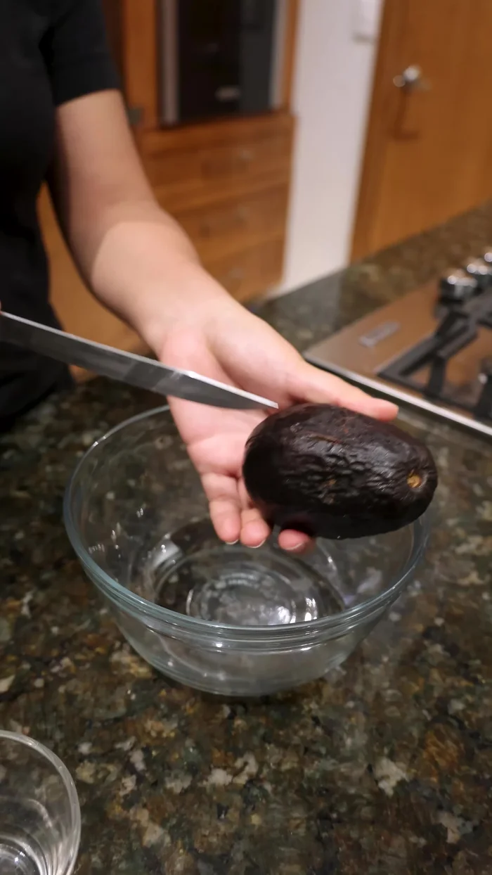 Separa los aguacates pasados del refrigerador, córtalos por la mitad y retira el hueso.
