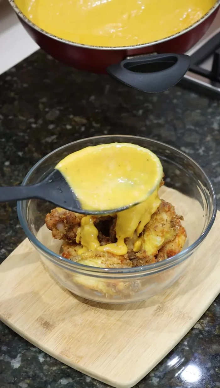 Agregar la salsa de mango habanero a las alitas fritas y mezclar bien.