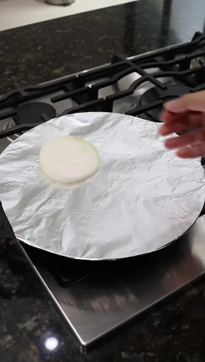 En un comal, asar una rodaja de cebolla, 4 chiles habanero y un diente de ajo sin cáscara hasta que estén tatemados.