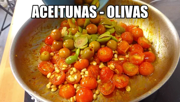 Fuera del fuego, incorporar los piñones tostados, las aceitunas, el perejil picado y dos dientes de ajo prensados (53.64).