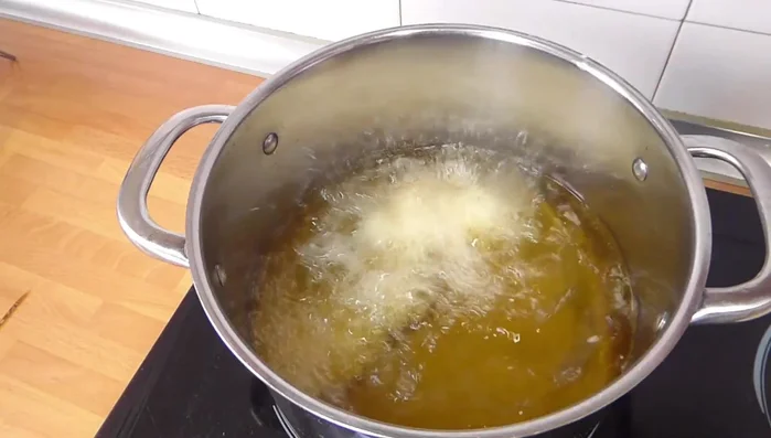 Freír el pollo: Calentar abundante aceite en una olla. Freír el pollo en porciones pequeñas, para asegurar una cocción uniforme, hasta que esté dorado y crujiente (105.88).