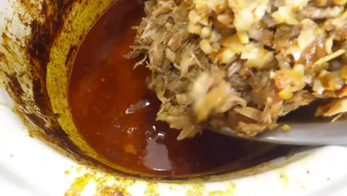 Mezclar la carne desmenuzada con la salsa de la olla lenta. (206.48)