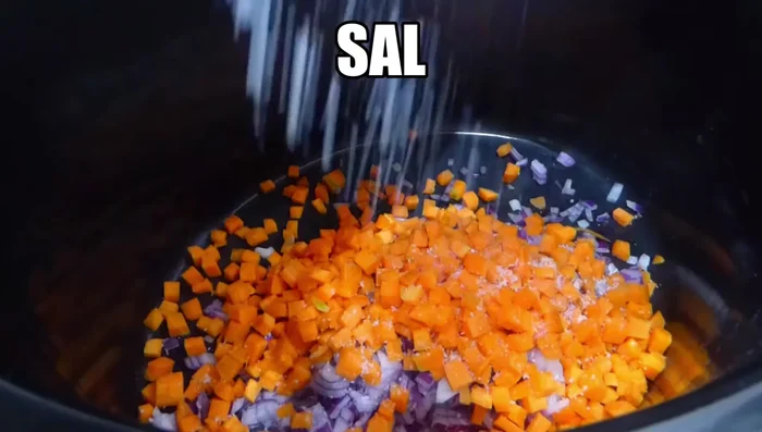 En la olla lenta, agregar cebolla y zanahoria picadas, sal, laurel, pimienta, ajos prensados, vino blanco y vinagre. Remover.