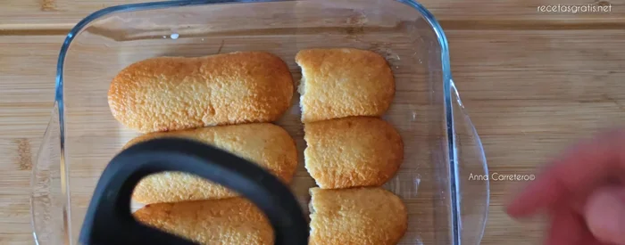 Vierte la crema de leche espesada encima de los bizcochos.