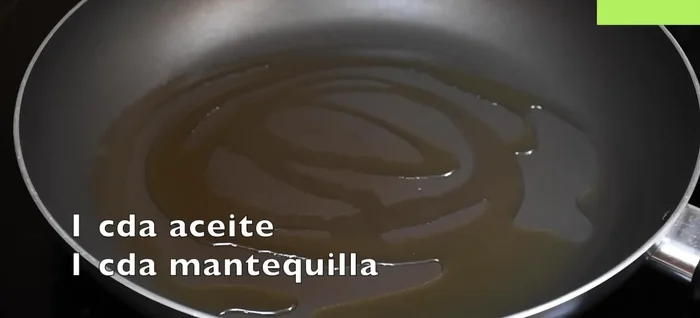 Calentar el aceite y la mantequilla en un sartén a fuego medio. Agregar un diente de ajo picado.