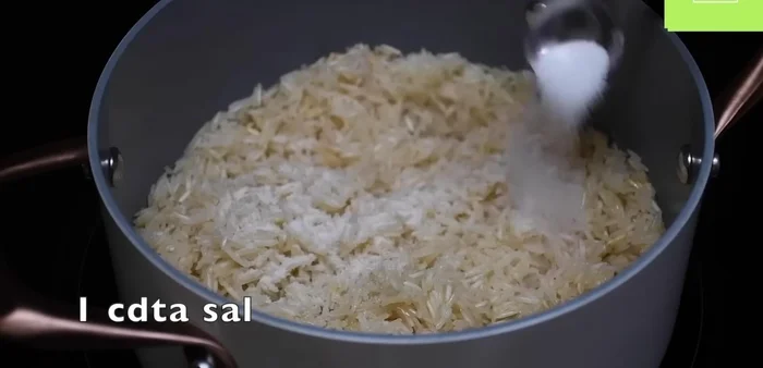 Agregar sal o consomé de pollo en polvo al arroz tostado. Sofreír hasta que el arroz esté bien caliente y tostado.