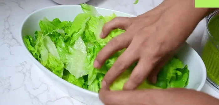 En un tazón grande, colocar la lechuga, las espinacas y las nueces.