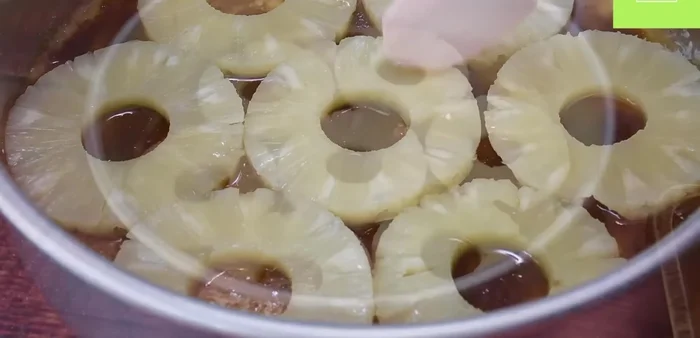 Añade las rodajas de piña sobre el azúcar morena.