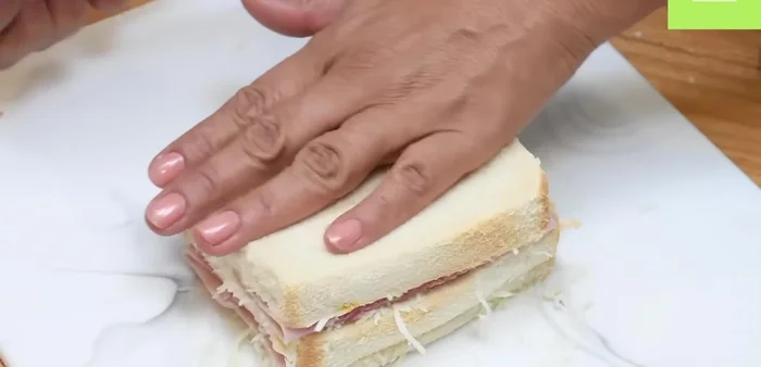 Aplastar ligeramente el sándwich para que los ingredientes se integren.