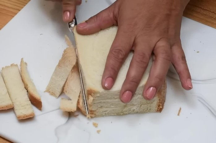Quitar las orillas a tres rebanadas de pan de molde fresco. Las orillas se pueden secar al sol y luego licuar para hacer pan rallado.