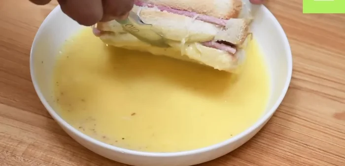 Mojar el sándwich en la mezcla de huevo por ambos lados.