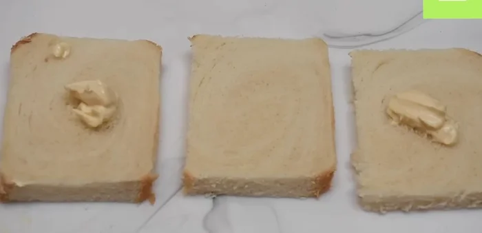 Untar mayonesa y mostaza en dos rebanadas de pan.