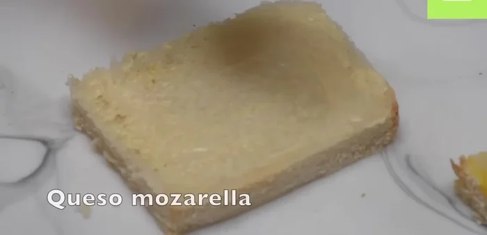 Agregar queso mozzarella y cuatro rebanadas de jamón a dos rebanadas de pan, formando dos mitades de sándwich.